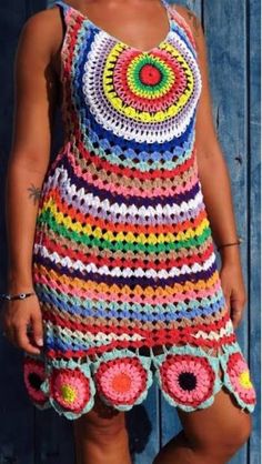 a woman wearing a multicolored crocheted dress