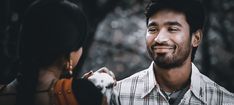 a man standing next to a woman with a smile on his face and looking at him