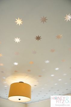 a ceiling with stars painted on it and a light fixture in the middle of the room