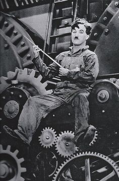 a man sitting on top of a machine with lots of gears in front of him