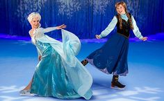 two women dressed as frozen princesses dancing on an ice rink with snowflakes in the background