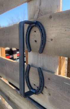 two horseshoes are attached to the side of a wooden fence