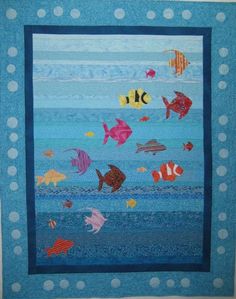 a quilted wall hanging with fish on it