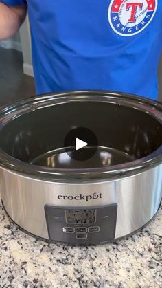 a man standing in front of a crockpot on top of a countertop