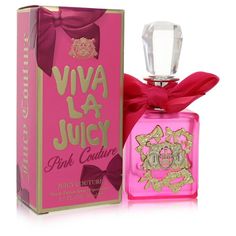 a pink perfume bottle with a red bow around it's neck next to a box