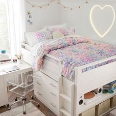 a white bed with drawers underneath it and a heart shaped light on the wall above it