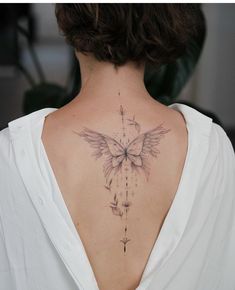 a woman with a butterfly tattoo on her back