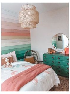 a bedroom with a bed, dresser and colorful striped wall paper on the walls behind it