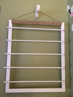 an old window is hung on the wall with clothes pins and a cork board attached to it