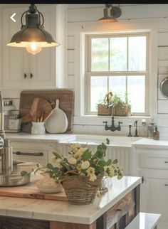 a kitchen with white cabinets and an island in front of the sink is filled with flowers