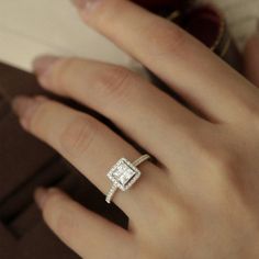 a woman's hand with a diamond ring on it