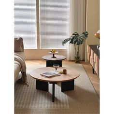 a living room with a couch, coffee table and window blinds on the windowsill