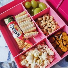 a pink lunch box filled with snacks and pretzels