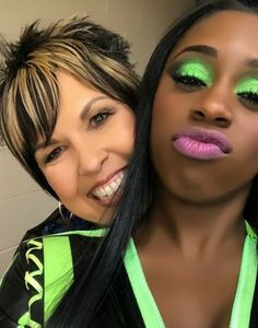 two women with bright green makeup posing for the camera