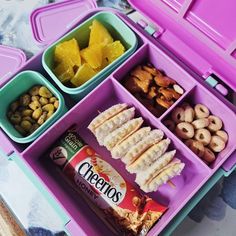 the lunch box is filled with different types of snacks and nuts, including bananas, pineapples, cashews, peanuts