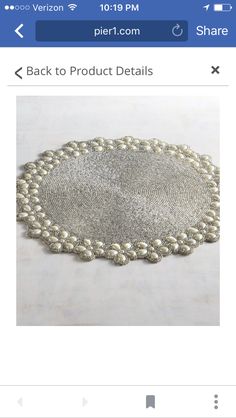 an image of a white doily with pearls on the bottom and one bead in the middle