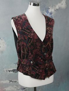 This stunning velvet vest has an abstract pattern on the front (and the three-quarter belt) in pale burgundy, blush pink, and slate gray. The German vintage pointed-front trachten waistcoat has a V neckline, and closes in the front with four replica antique germanic coin buttons. Four of those buttons decorate the belt. The back and lining is a black satin viscose fabric. Bust = 42 inches (107cm) Waist = 37 inches (93.98cm) Vest Length = 23 inches (58.42cm) Brand label: Original Alphorn Size lab Cottagecore Vest, Cute Vests, Royal Blue Coat, Vintage Waistcoat, Silly Clothes, Floral Vest, Velvet Vest, Floral Vests, Women's Vest