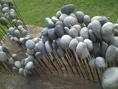 a bunch of rocks that are sitting on the ground next to each other with hair pins sticking out of them