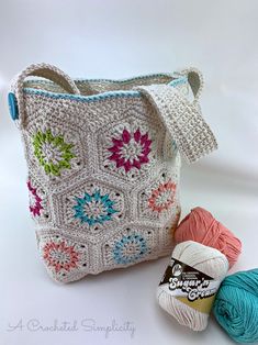 two balls of yarn are next to a crocheted bag