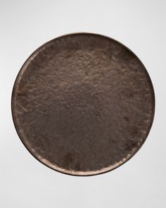 an old, rusty metal plate is shown in the air on a white background with no one around it