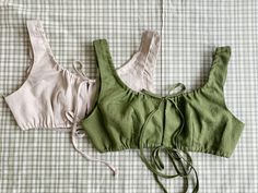 two green and white bras laying on top of a bed next to each other