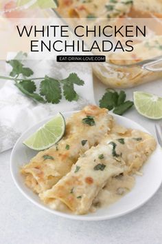 white chicken enchiladas on a plate with limes and cilantro