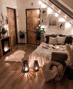 a bedroom with wooden floors and lights on the wall above the bed is lit by candles