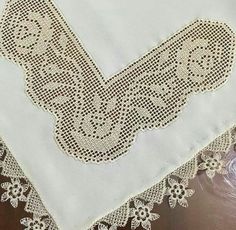 a close up of a white table cloth with lace on it and an ornate design