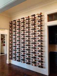 a wall full of wine bottles in the middle of a room