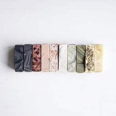 five different types of soaps lined up in a row on a white surface,