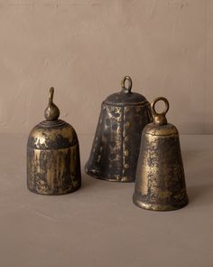 three brass bell shaped objects sitting on a table