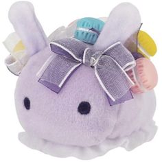 a purple stuffed animal with a bow on its head and hair comb in it's ear