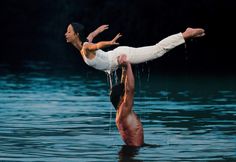 a man doing a handstand in the water with a woman on his back
