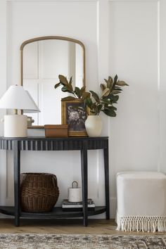 a black table with a mirror and some plants on it