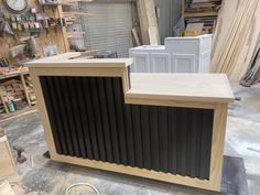 a wooden counter sitting on top of a floor next to other woodworking tools and supplies