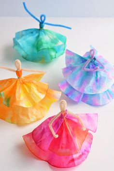 four different colored tissue paper bags with string on the top and one in the middle