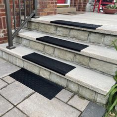 three black mats on the steps leading up to a house