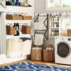 a washer and dryer in a room with baskets on the wall next to it