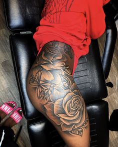 a woman sitting in a chair with her legs crossed and tattoos on the leg area