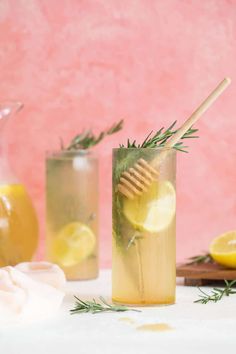 two glasses filled with lemonade, rosemary and honey