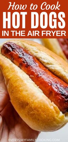 a hot dog in a bun with ketchup and mustard on it is being held by someone's hand