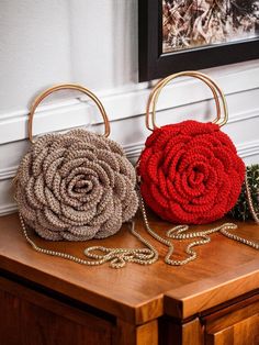 two purses sitting on top of a wooden table