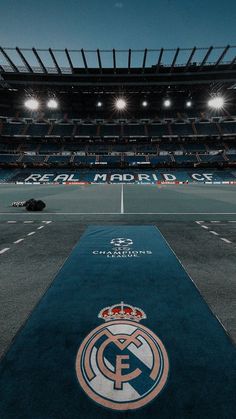 an empty soccer field at night with the lights on