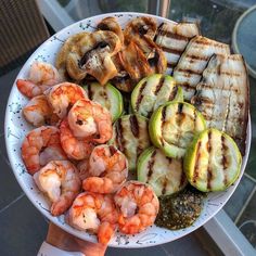 a white plate topped with grilled vegetables and shrimp