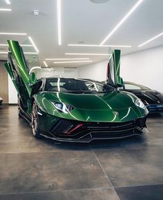 two green sports cars parked in a garage