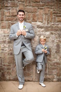 a man in a gray suit standing next to a little boy