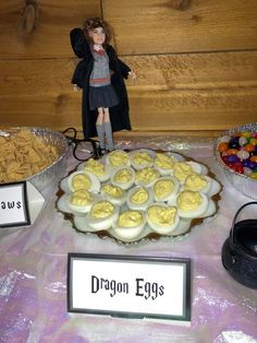 a table topped with lots of food next to a sign that says dragon eggs on it