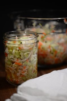 two jars filled with food sitting on top of a wooden table