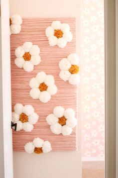 a pink wall hanging with white flowers on it