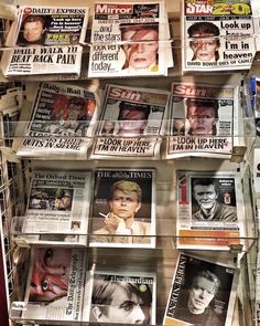 newspapers on display in a store window with people's faces painted on the front